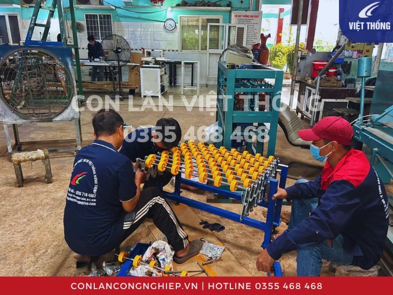 Đội thợ kỹ thuật đang lắp ráp băng tải con lăn xếp tại xưởng Việt Thống