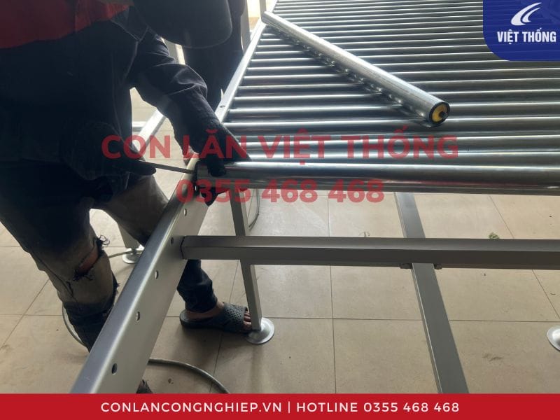 Lắp đặt con lăn vào khung băng tải